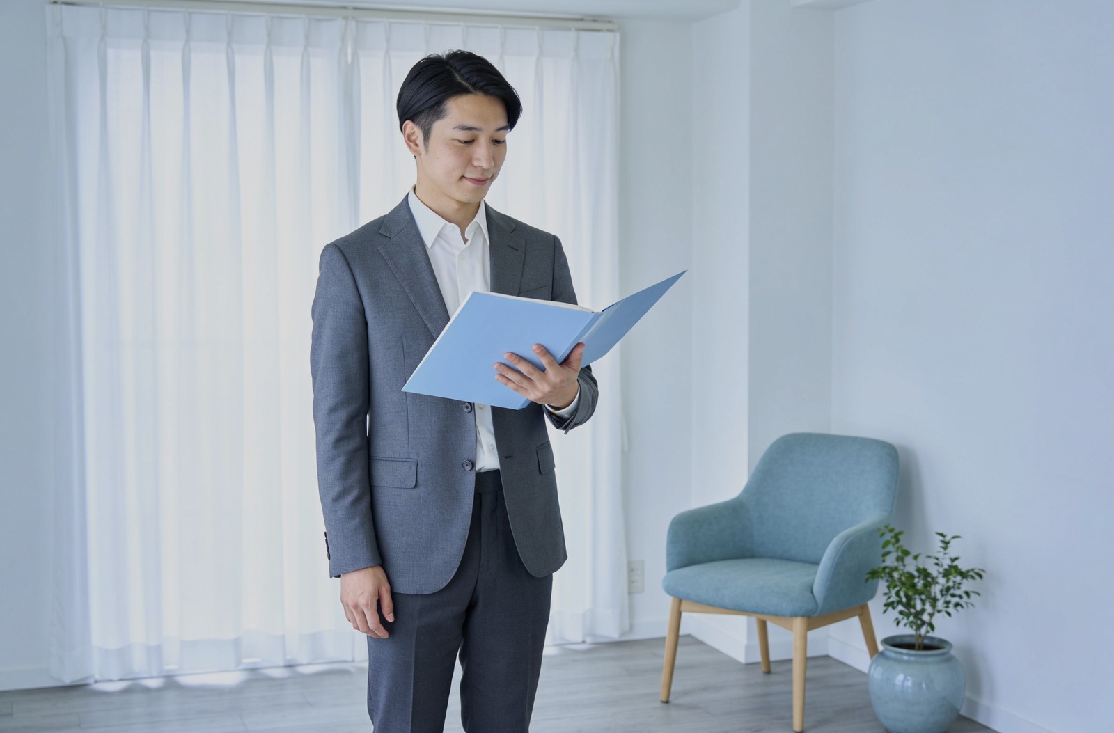 内見中の部屋で、担当者が資料を手に立って説明している